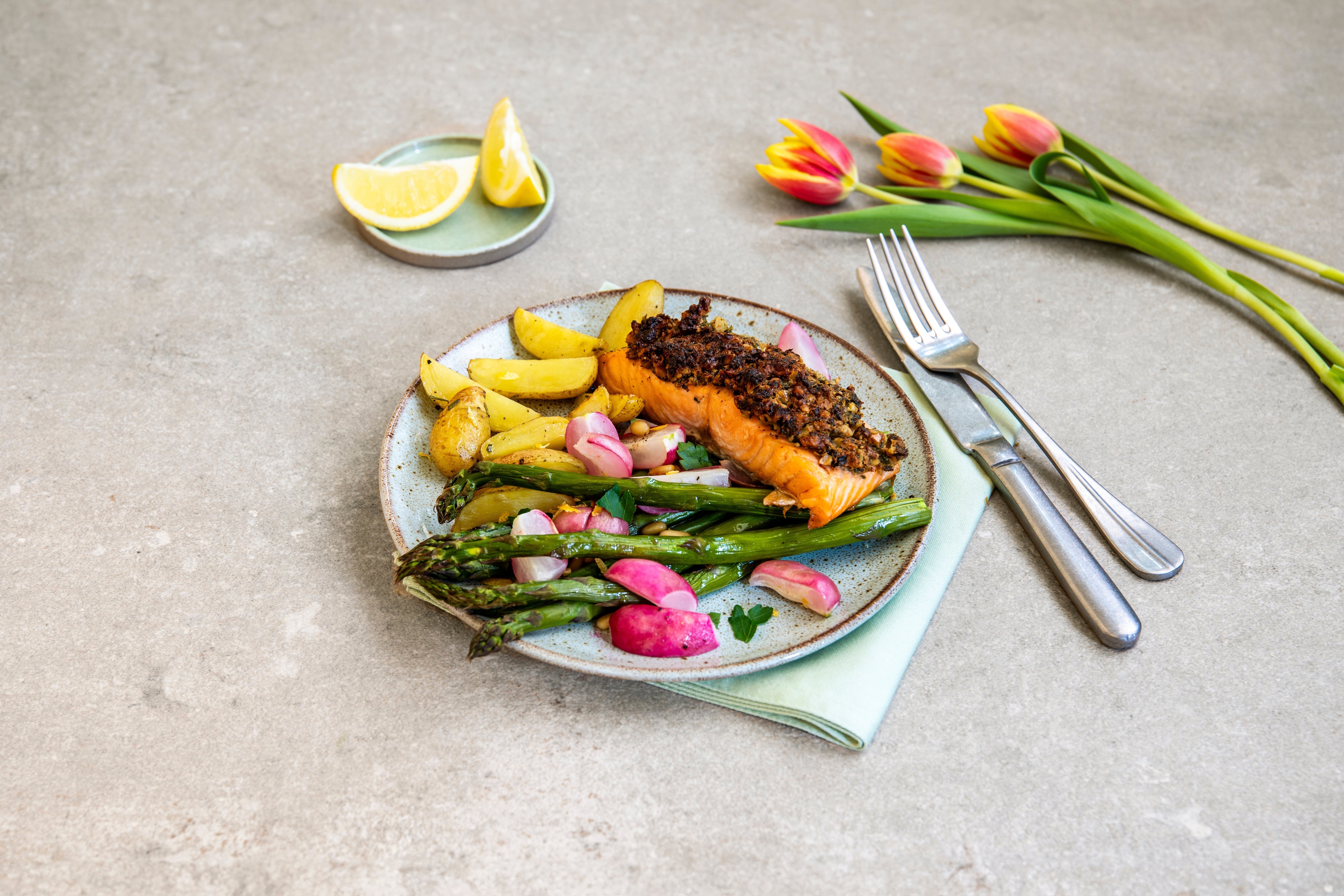 Lachsfilet mit Kräuterkruste auf grünem Spargel mit Radieschen und Kar