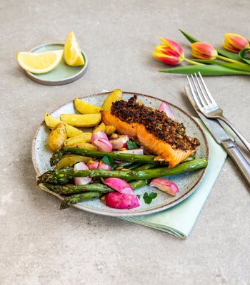 Lachsfilet mit Kräuterkruste auf grünem Spargel mit Radieschen und Kartoffeln